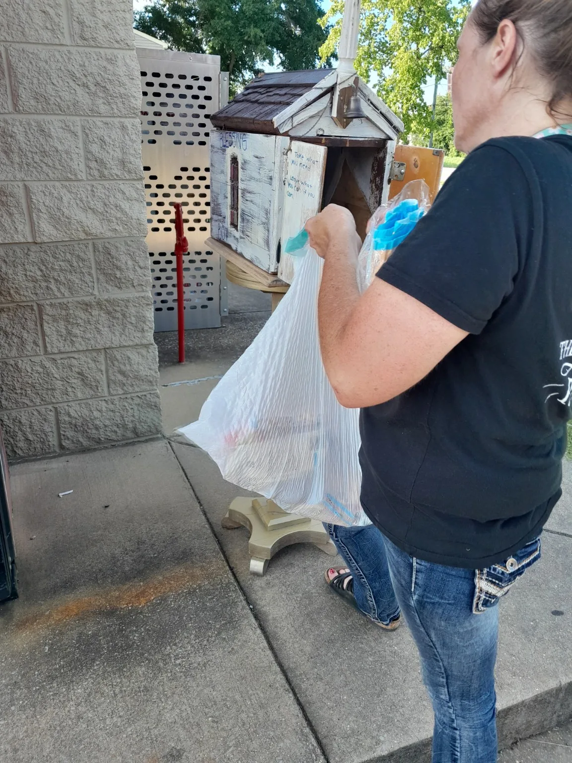 A community member placing supplies in a Blessing Box