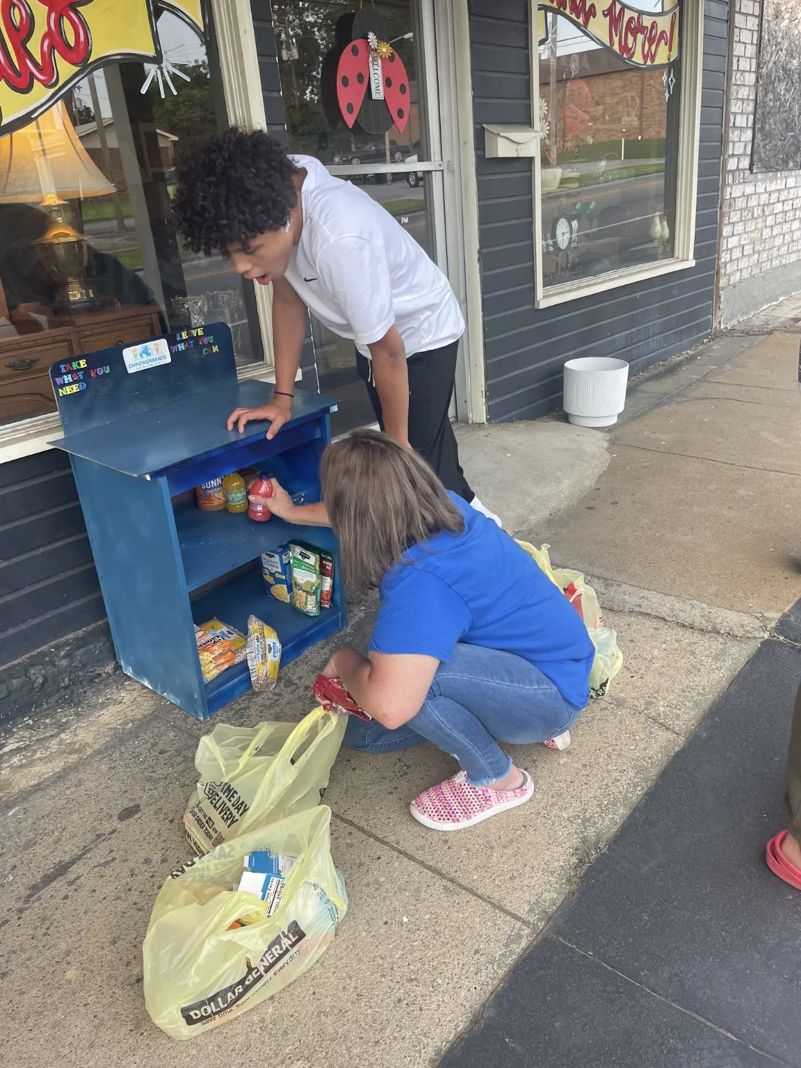 Volunteers stocking a blue Blessing Box